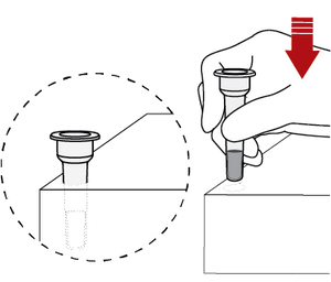 The tube holder is a perforated circle on the bottom right corner of the box. A hand pushes the tube through the circle and leaves the tube standing upright